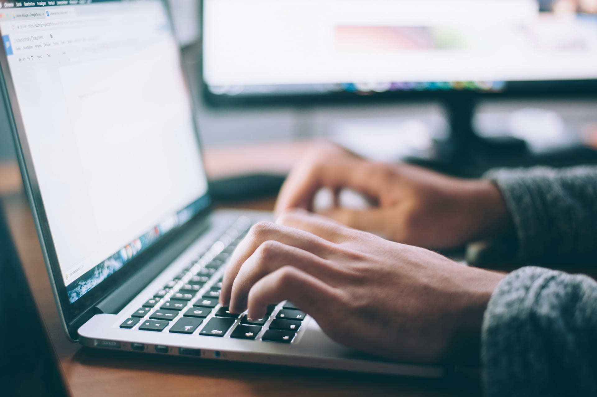A laptop and notebook on a clean desk, ready for the next message